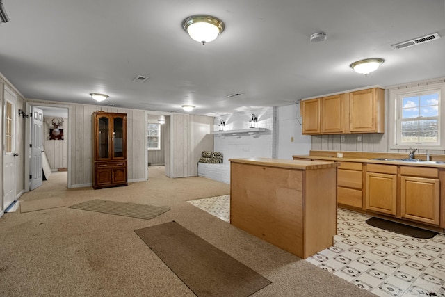 kitchen with a center island, sink, and light brown cabinets