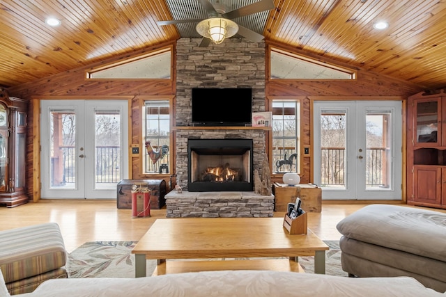 living room with vaulted ceiling, a wealth of natural light, light hardwood / wood-style floors, and french doors