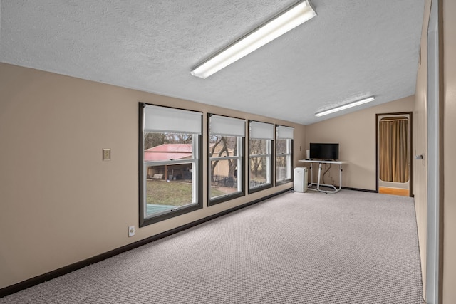 carpeted spare room featuring lofted ceiling and a textured ceiling