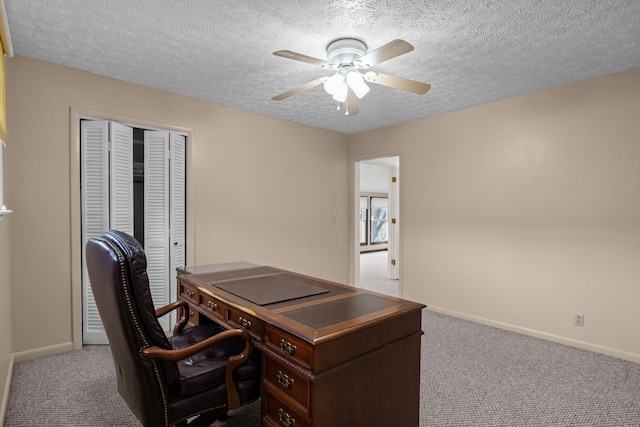 carpeted office featuring a textured ceiling and ceiling fan