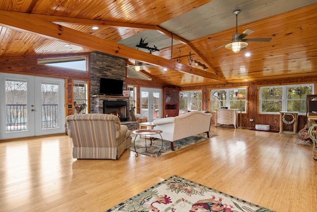 living room with a healthy amount of sunlight, light hardwood / wood-style floors, and french doors