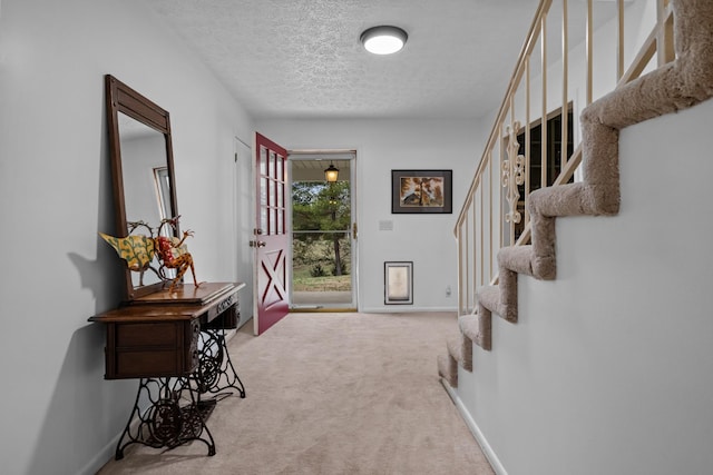 hall with carpet flooring and a textured ceiling