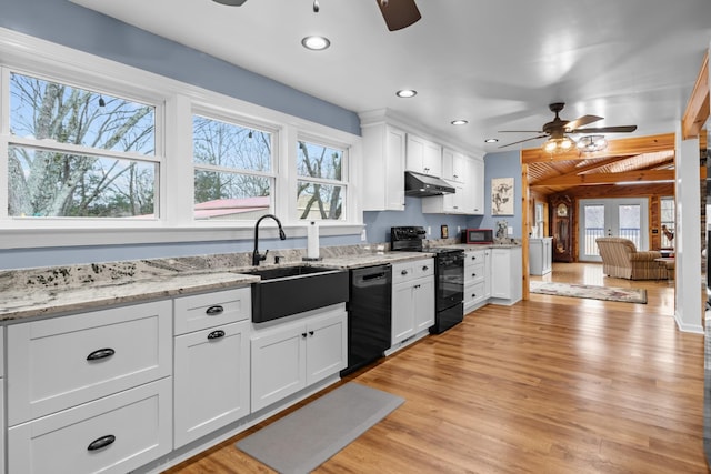 kitchen featuring sink, black appliances, white cabinets, and light stone countertops