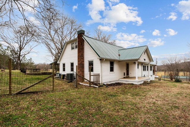 back of house featuring a yard and central AC unit