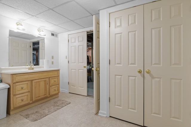 bathroom with vanity and a drop ceiling