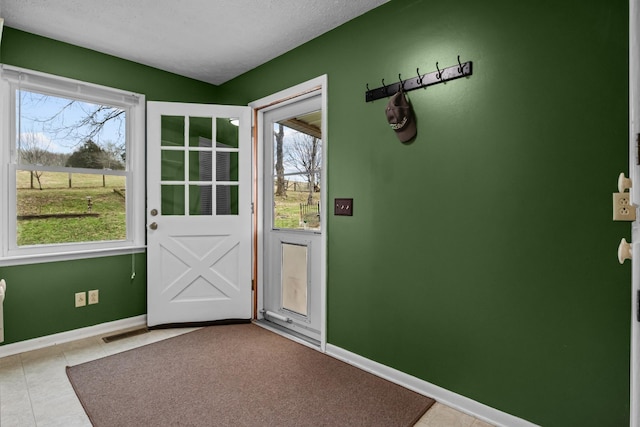 doorway featuring a textured ceiling and light tile patterned floors