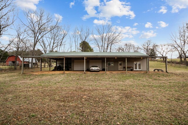 back of house with a carport and a yard