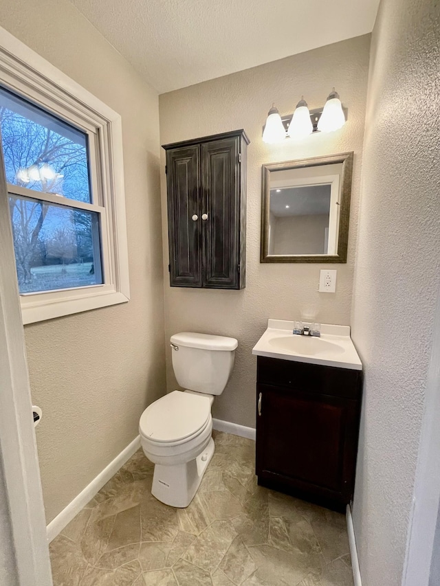 bathroom with vanity, a textured ceiling, and toilet