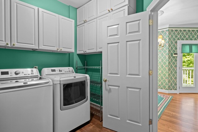laundry area featuring separate washer and dryer, cabinets, and light wood-type flooring