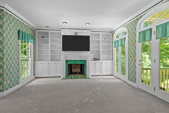 unfurnished living room with crown molding, carpet floors, built in features, and a fireplace