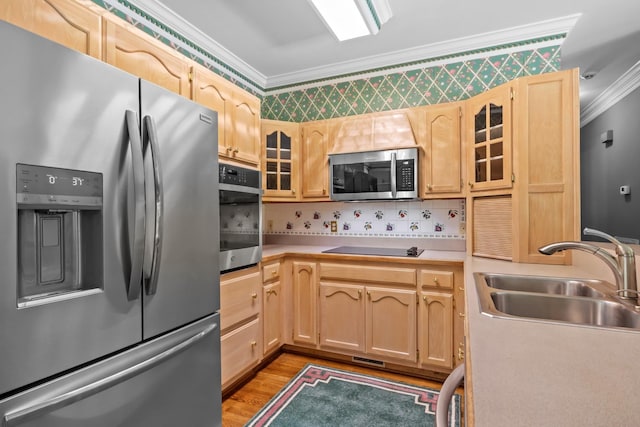 kitchen with sink, light hardwood / wood-style flooring, appliances with stainless steel finishes, ornamental molding, and light brown cabinets