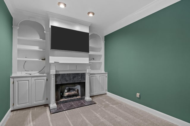 unfurnished living room with light carpet, built in shelves, a high end fireplace, and crown molding