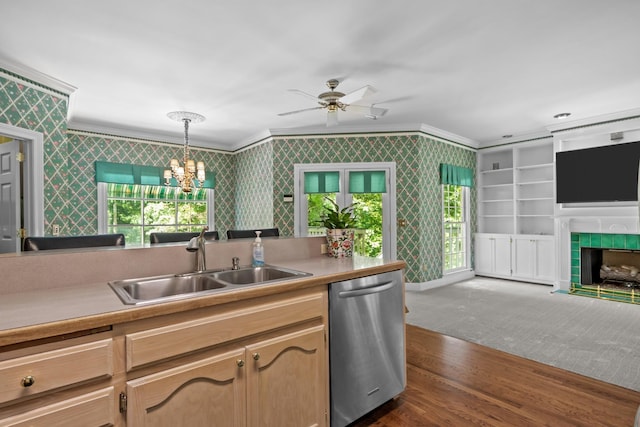 kitchen featuring dishwasher, sink, ornamental molding, and decorative light fixtures