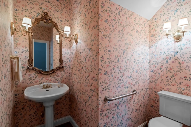 bathroom with vaulted ceiling, sink, and toilet