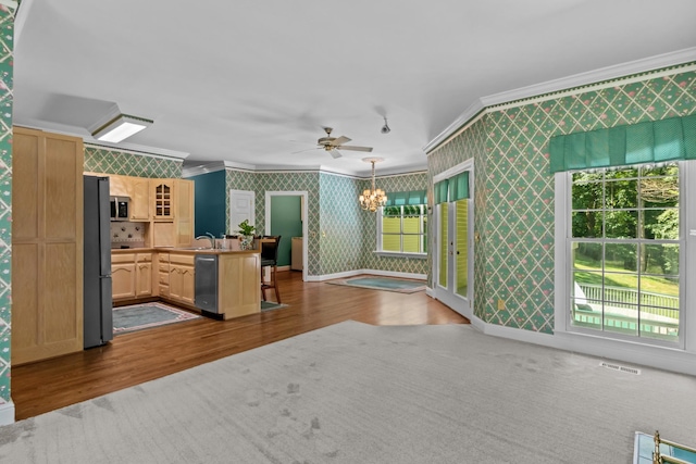 kitchen featuring light brown cabinetry, decorative light fixtures, dark hardwood / wood-style flooring, ornamental molding, and stainless steel appliances