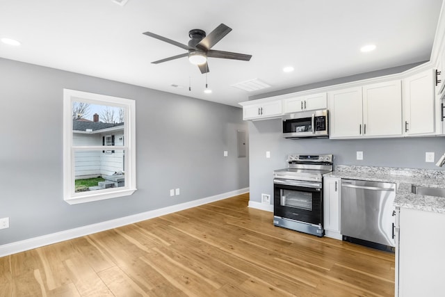 kitchen with appliances with stainless steel finishes, sink, a wealth of natural light, and white cabinets