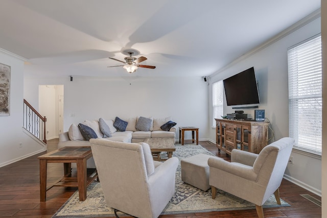 living room with dark wood-type flooring, ornamental molding, ceiling fan, and plenty of natural light