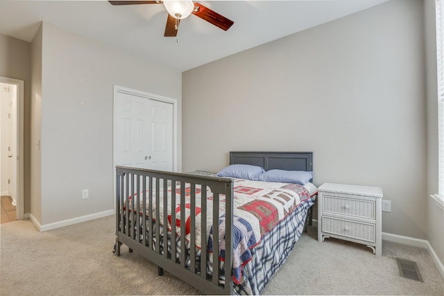 carpeted bedroom with ceiling fan and a closet