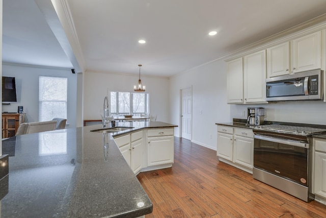 kitchen with sink, crown molding, stainless steel appliances, and white cabinets