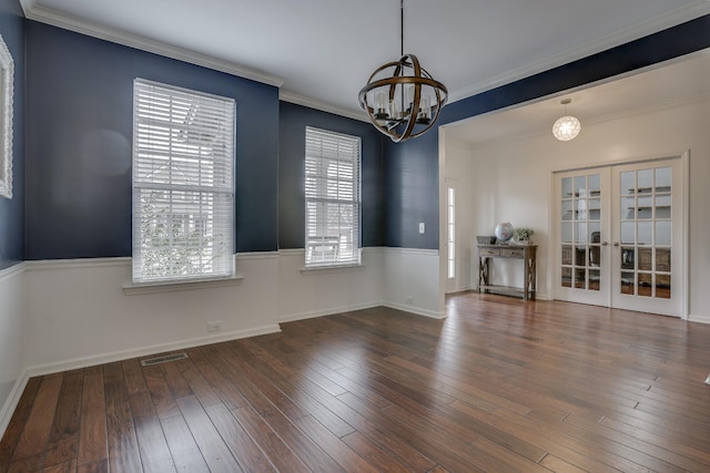 unfurnished room with crown molding, dark wood-type flooring, a chandelier, and french doors