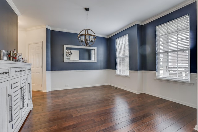 unfurnished dining area with ornamental molding, dark hardwood / wood-style floors, and a notable chandelier