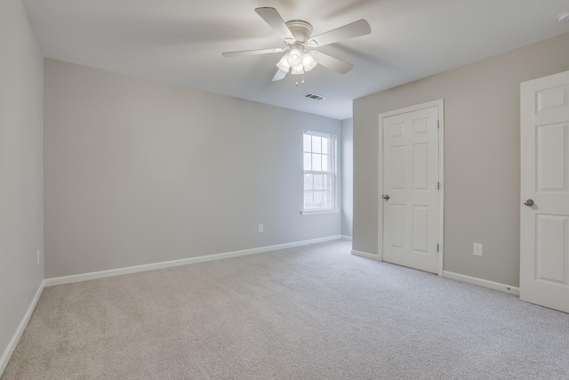 empty room with ceiling fan and light colored carpet