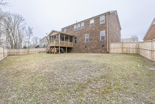 back of property with a deck, a sunroom, and a lawn