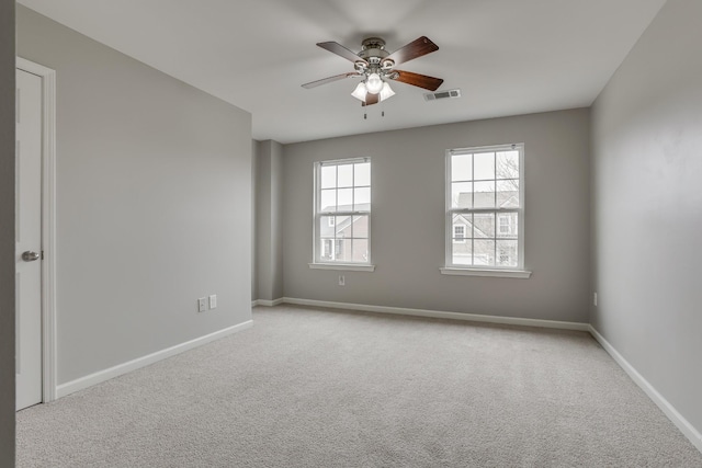 carpeted spare room featuring ceiling fan