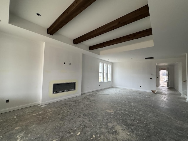 unfurnished living room featuring beamed ceiling