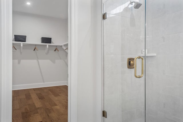 bathroom with wood-type flooring and a shower with shower door