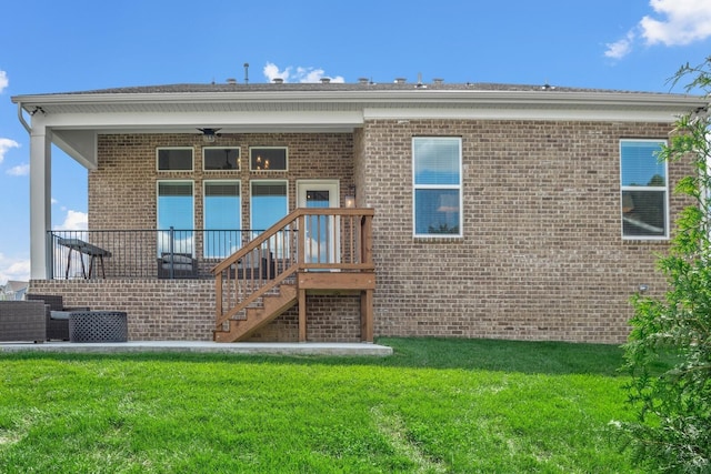 rear view of house with ceiling fan and a yard