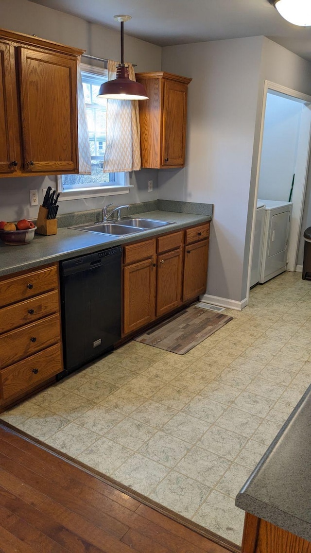 kitchen featuring black dishwasher, sink, and washer / dryer