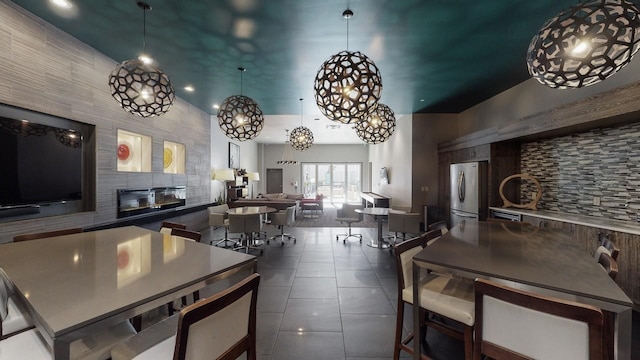 kitchen with decorative backsplash, stainless steel fridge, and dark tile patterned floors