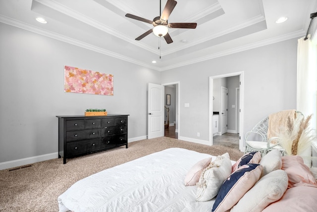 bedroom featuring crown molding, a tray ceiling, ceiling fan, and carpet flooring