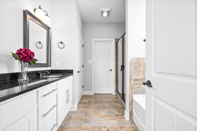 bathroom with vanity and shower with separate bathtub