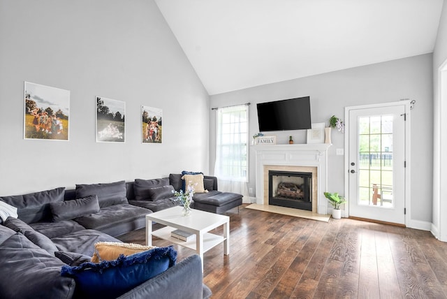 living room with plenty of natural light, hardwood / wood-style floors, and high vaulted ceiling