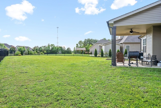 view of yard with ceiling fan and a patio area