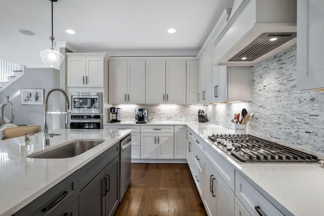 kitchen featuring white cabinetry, appliances with stainless steel finishes, decorative light fixtures, and sink