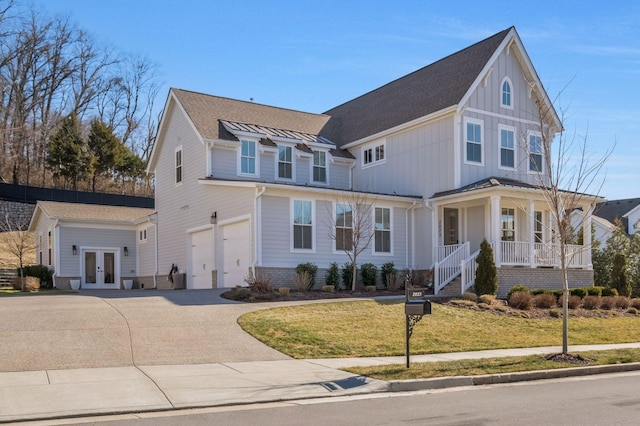 view of front of property featuring a garage, a porch, a front yard, and french doors