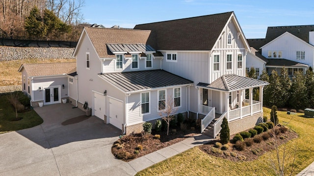 view of front of property with a garage, covered porch, and french doors