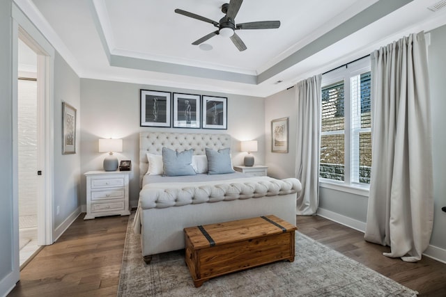 bedroom with crown molding, dark hardwood / wood-style floors, and a raised ceiling