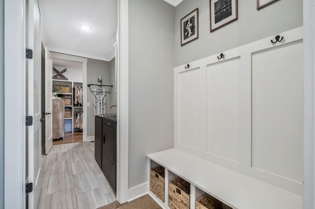 mudroom featuring crown molding and washer and dryer