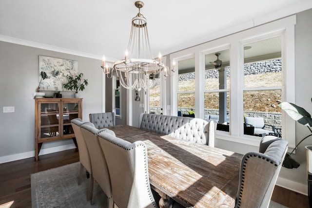 dining space featuring dark wood-type flooring, crown molding, and ceiling fan with notable chandelier