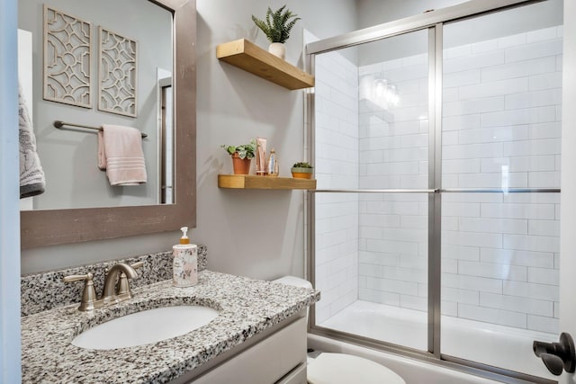 full bathroom with vanity, shower / bath combination with glass door, and toilet