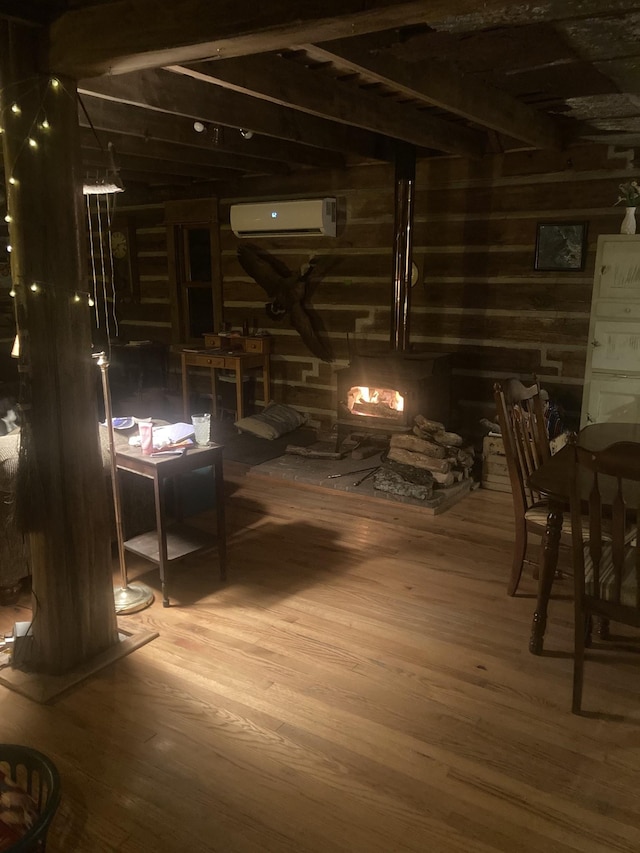 basement featuring a wall mounted air conditioner and hardwood / wood-style flooring