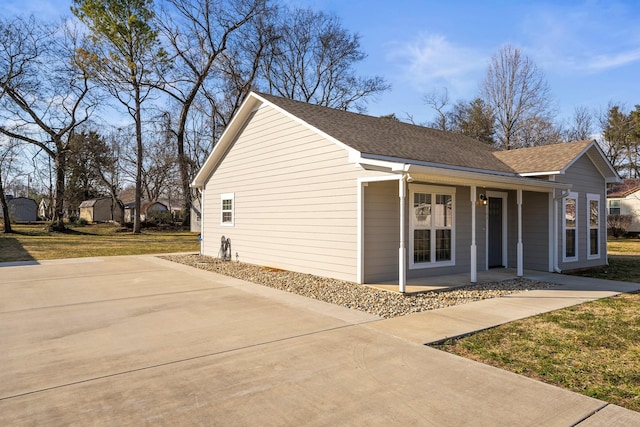 view of side of property featuring a porch and a lawn