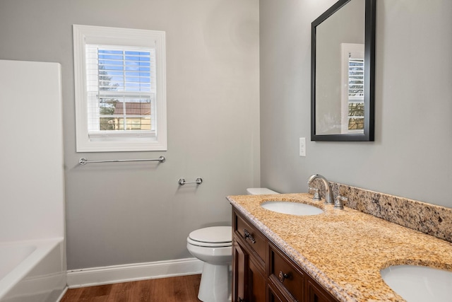 bathroom with vanity, toilet, wood-type flooring, and a tub