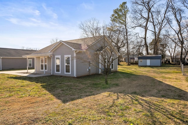 view of side of home featuring a storage shed, a patio area, and a lawn