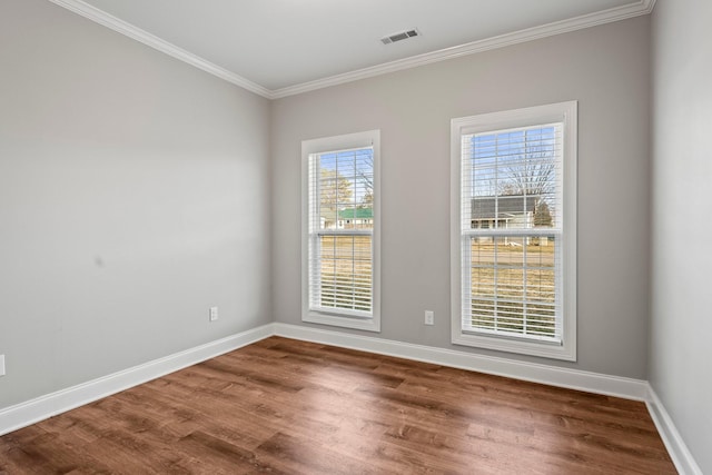 empty room featuring hardwood / wood-style flooring and ornamental molding