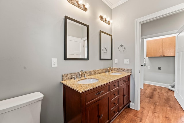 bathroom featuring hardwood / wood-style flooring, vanity, toilet, and crown molding